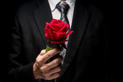 Man in a Suit Holding a Red Rose