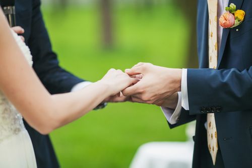 Minister Holding Hands of Bride and Groom