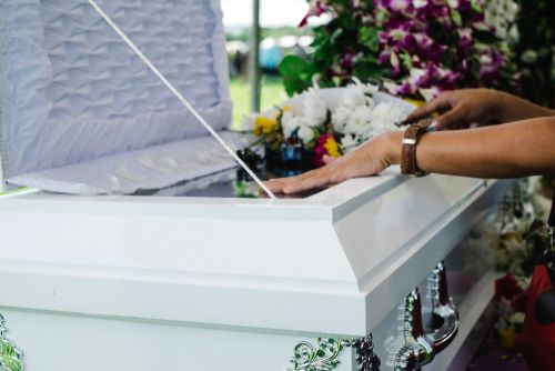 Person Examining a Coffin