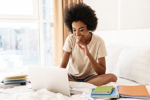 A Woman in Bed Looking at Her Computer