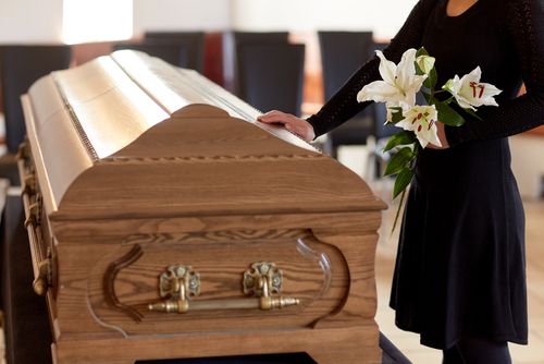 Woman Standing in Front of a Coffin