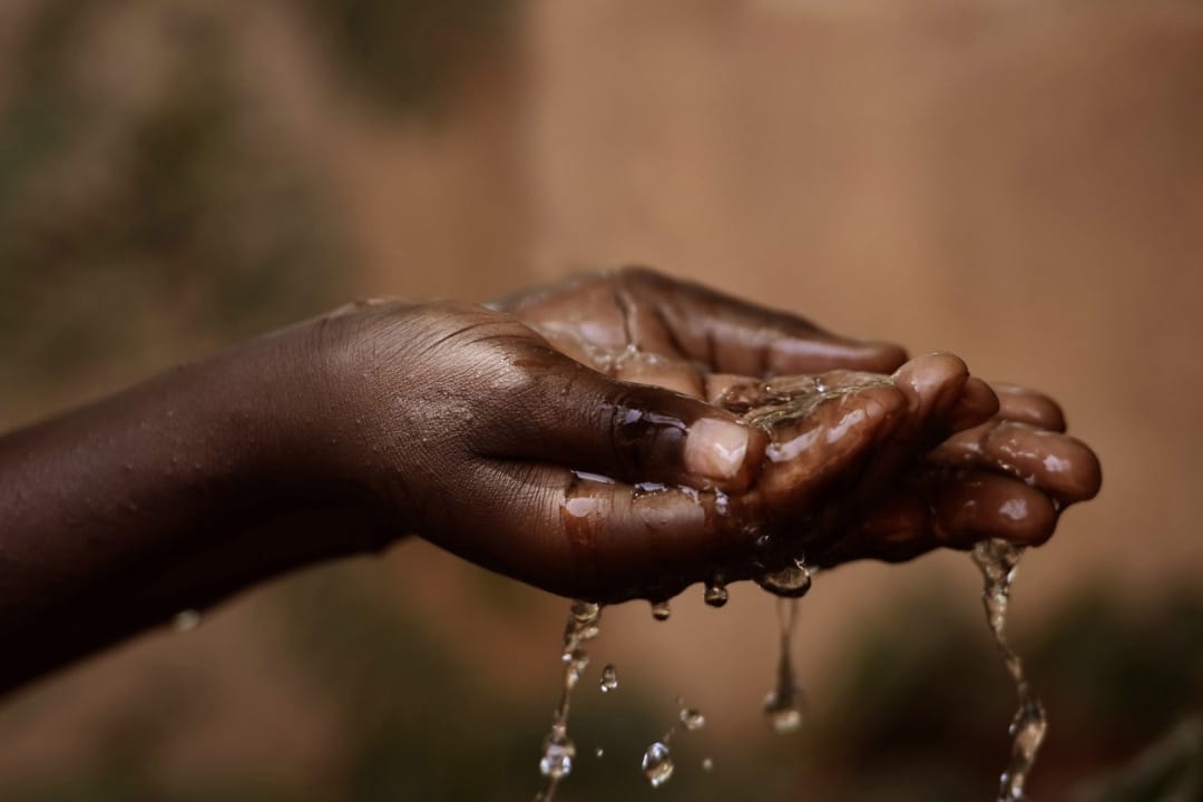 Hands cupping water at baptism